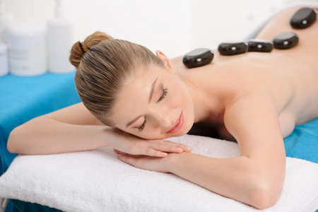 A young woman having a hot stone massage.の写真素材