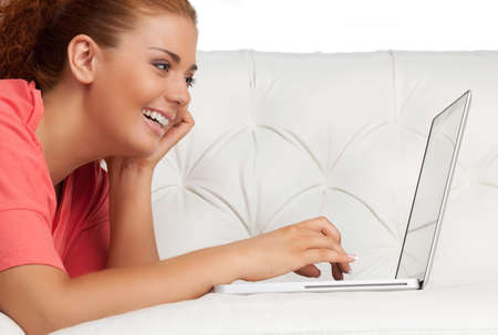 Woman with laptop. Cheerful young woman using laptop and smilingの写真素材