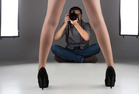 Photographer and model. Confident young man photographing model at studioの写真素材