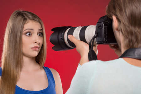 Photographer and model. Young man photographing model at studioの写真素材