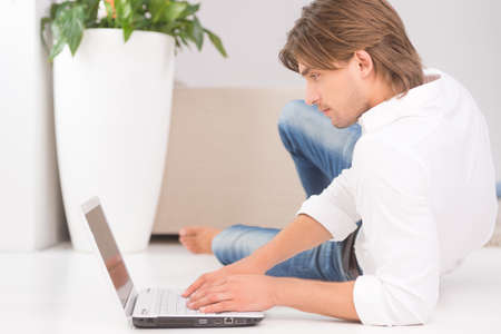 Man with laptop. Confident young man working at the laptopの写真素材