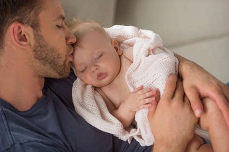 Man with baby. Young muscular man holding baby and kissing himの写真素材