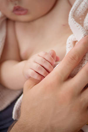Father with baby. Little baby holding fathers finger and sleepingの写真素材