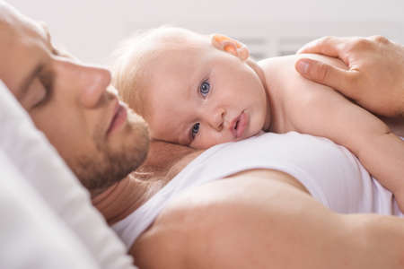 Father and baby. Young father and baby sleeping togetherの写真素材