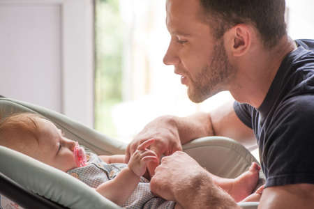 Man with baby. Young father looking at his little childの写真素材