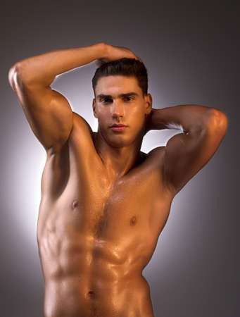 Muscular man. Muscular man posing while standing isolated on whiteの写真素材