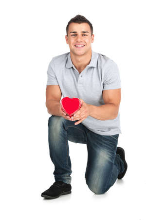 Gift box  Handsome young man holding a gift box while standing against white backgroundの写真素材