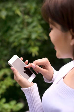 Women with mobile phone  Top view of young women holding mobile phone in her hand and smilingの写真素材