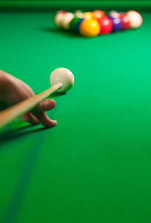 Billiards. Close-up of someone aiming the billiard ball with cueの写真素材