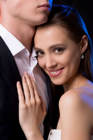 Loving couple. Beautiful young woman leaning to her boyfriend and smilingの写真素材