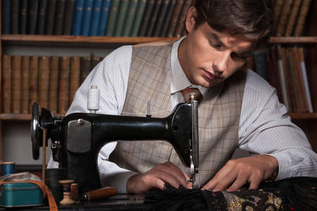 Tailor at work. Confident young man working at the tailor shopの写真素材