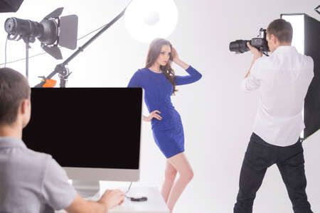 Photographer and model at studio. Young man photographing model at studioの写真素材