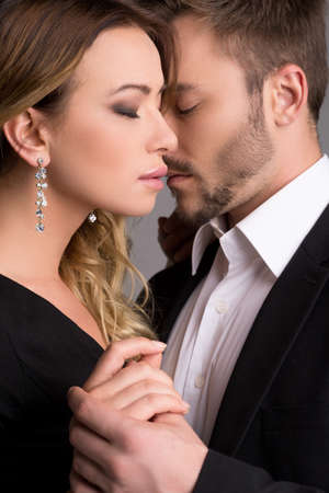 Loving couple. Beautiful young couple in formalwear standing close to each other and keeping eyes closedの写真素材