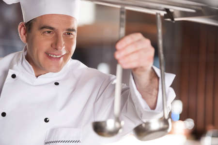 Preparing to work. Cheerful chef preparing cooking stuff before workの写真素材