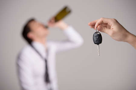 Holding car keys with drinking man 