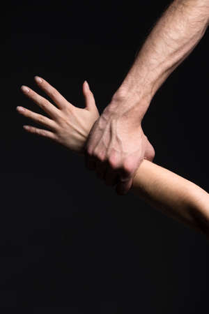 Close up of man's and woman's hands. Isoleted on black