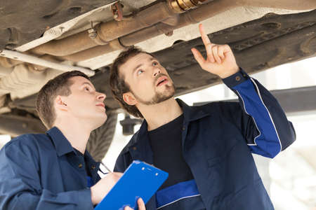 Mechanics at work. Two confident mechanics working at the work shopの写真素材