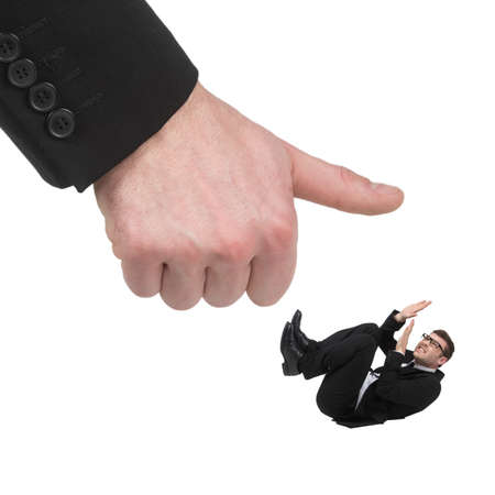 Please, no! Terrified young businessmen lying on his back while a huge human finger trying to smash him while isolated on whiteの写真素材