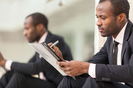 Businessman sits and work with documentの写真素材