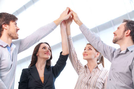 Business team is holding hands together. Raising one hand upの写真素材