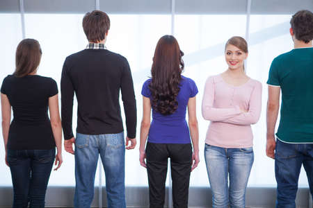View from behind of Group of people. One girl facing a cameraの写真素材