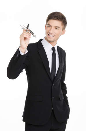 Adult businessman in suit holding a plane isolated on whiteの写真素材