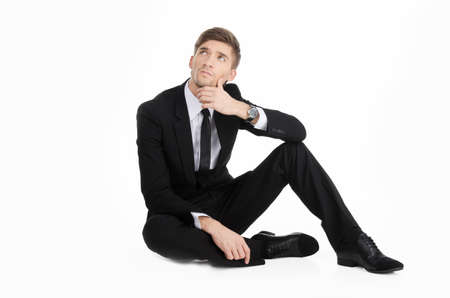 Businessman in a suit sits and thinkingの写真素材