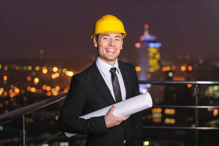 Satisfied Architect on background night city with plans