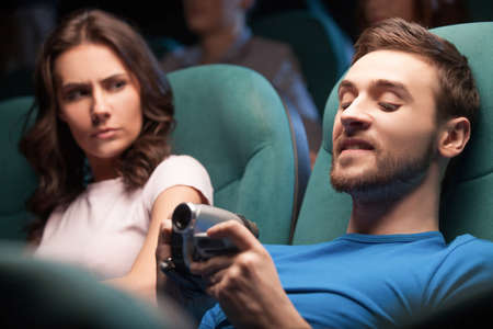 Men pirating. Young men pirating at the cinema while women looking at himの写真素材