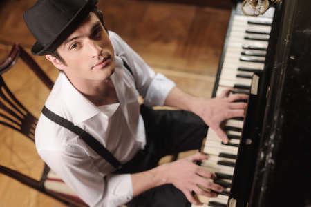Expressing myself with music. Top view of handsome young men playing piano and looking at camera