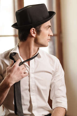 Tired of his tie. Handsome young stylish menの写真素材