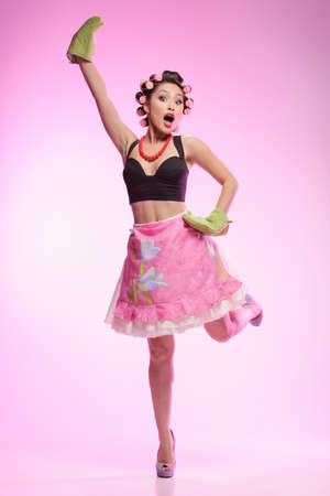 I?m the best housewife! Sexy young housewife wearing gloves and standing on one leg with her right hand upの写真素材