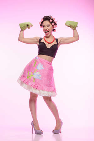 The sexiest housewife ever. Sexy young housewife wearing gloves and standing with her hands upの写真素材