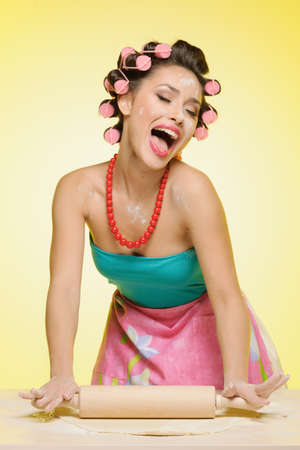 Singing her favorite song. Sexy young housewife kneading the dough and singingの写真素材