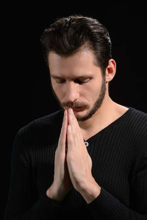 Man praying. Portrait of bearded man praying and holding his hands claspedの写真素材