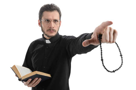 Do you believe in God? Portrait of priest pointing away while standing isolated on whiteの写真素材