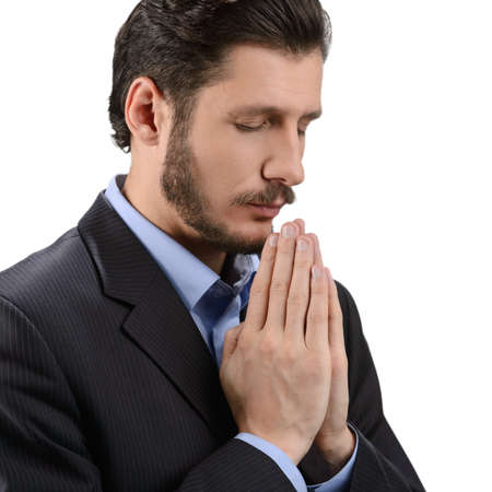 Businessman praying. Portrait of bearded man praying and holding his hands claspedの写真素材