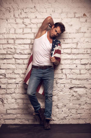 Sexy male model posing with white T-shirt and jeans on. Looking stylishの写真素材