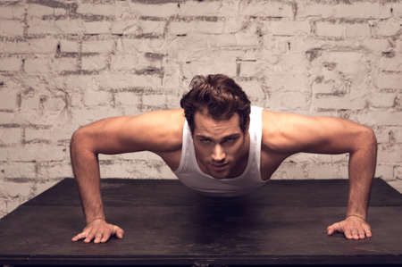 Sexy man is doing exercise. While looking at camera, close upの写真素材