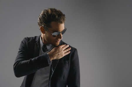 Everything should be perfect. Portrait of handsome young men in sunglasses standing isolated on greyの写真素材