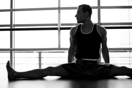 Sportsman warming up. Black and white image of young sportsman warming up and looking awayの写真素材
