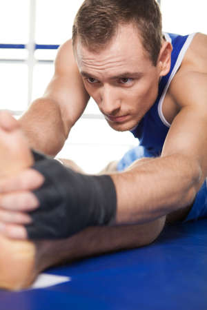 Boxer warming up. Young sportsman in gloves warming up and stretchingの写真素材
