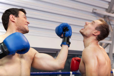 Final punch. Boxer punching his opponent on the ringの写真素材
