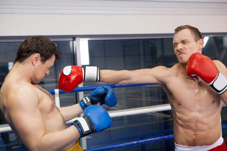 Good punch. Boxer punching his opponent on the ringの写真素材