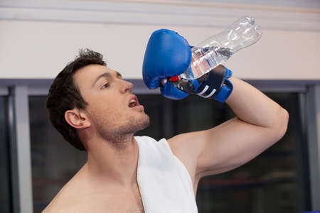 Boxer drinking water. Confident young boxer drinking water after trainingの写真素材