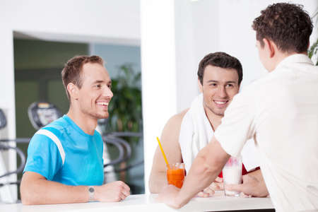 Healthy lifestyle. Two confident men in juice barの写真素材