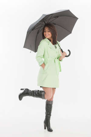 Women with umbrella. Full length of beautiful young women holding an umbrella and smiling while isolated on whiteの写真素材