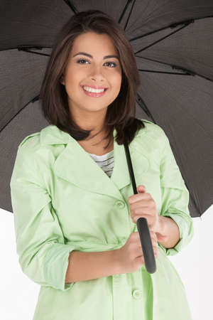 Beautiful women with umbrella. Attractive young women holding an umbrella and smiling at camera while isolated on whiteの写真素材