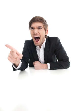 Angry businessman. Angry young businessman shouting and pointing away while isolated on whiteの写真素材