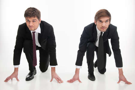 Business competition  Two angry young business people standing at the start line while isolated on whiteの写真素材